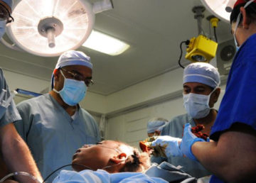 Sanjay Gupta, Henri Ford, and two U.S. Navy doctors operate on a Haitian girl aboard the USS Carl Vinson following the January 2010 earthquake in Haiti.