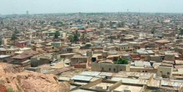 Kano, capital del Borno, Nordest della Nigeria. "KanofromDalaHill" by Shiraz Chakera - Kano from Dala Hill. Licensed under CC BY-SA 2.0 via Wikimedia Commons