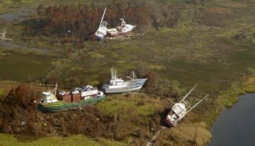 Bayou La Batre: nave cargo e barche da pesca portate sulla terraferma dalle acque "Katrina Bayou La Batre 2005 boats ashore" di NOAA, agency of US Federal Government