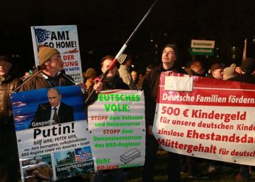 "Putin, hilf uns, rette uns!" ("Putin, help us, save us!") and other slogans on signs and banners. Photo by blu-news.org - Pegida Demonstration in Dresden am 05.01.2015, CC BY-SA 2.0, https://commons.wikimedia.org/w/index.php?curid=37967995