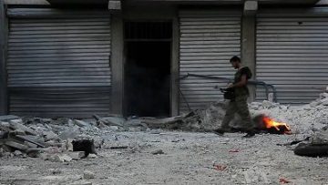 Un soldato del Free Syrian Army passeggia per Aleppo. Foto di Scott Bobb, via Wikimedia Commons, 2012.