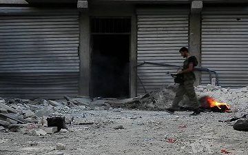 Un soldato del Free Syrian Army passeggia per Aleppo. Foto di Scott Bobb, via Wikimedia Commons, 2012.