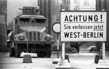 Filo spinato e autoblindo sulla linea di divisione alla Porta di Brandeburgo all'inizio dell'agosto 1961. Il cartello avverte: Attenzione! In questo momento state lasciando Berlino Ovest Di Bundesarchiv, Bild 173-1282 / Helmut J. Wolf / CC-BY-SA 3.0, CC BY-SA 3.0 de, https://commons.wikimedia.org/w/index.php?curid=5338533