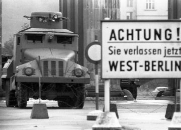 Filo spinato e autoblindo sulla linea di divisione alla Porta di Brandeburgo all'inizio dell'agosto 1961. Il cartello avverte: Attenzione! In questo momento state lasciando Berlino Ovest Di Bundesarchiv, Bild 173-1282 / Helmut J. Wolf / CC-BY-SA 3.0, CC BY-SA 3.0 de, https://commons.wikimedia.org/w/index.php?curid=5338533