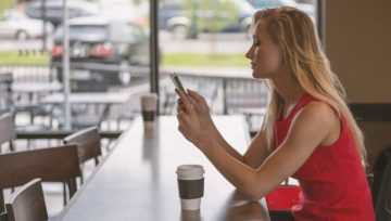 Ragazza con cellulare al bar, foto di Unsplash, CC0 Public Domain