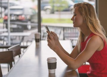 Ragazza con cellulare al bar, foto di Unsplash, CC0 Public Domain