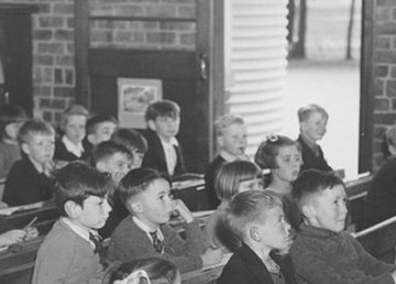 Bambini seguono una lezione in classe a Drouin, Australia. Foto via National Library of Australia, Flickr.