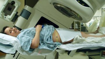 Una paziente si sottopone ad una seduta di radioterapia, effettuata per mezzo di un acceleratore lineare. Foto di Dina Wakulchik from Indianapolis, Indiana, USA - Zapping from a different angle..., CC BY 2.0, https://commons.wikimedia.org/w/index.php?curid=5784205