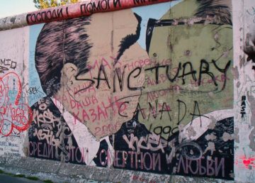 Su questo graffito del muro di Berlino ci sono Brežnev ed H00onecker che si baciano. La frase in alto in cirillico dice: "Signore! Aiutami a sopravvivere a questo amore letale" (photo by Dmitry Vrubel, 1989 )