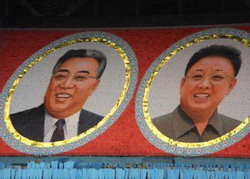 Portraits of Kim Jong-un's father and grandfather (Arirang Festival mass games in Pyongyang) By Laika ac from USA - Arirang Mass Games, CC BY-SA 2.0, https://commons.wikimedia.org/w/index.php?curid=31723854